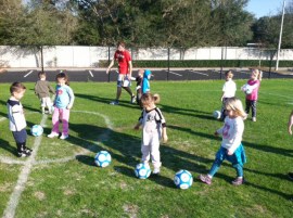 The Greater Palm Harbor Branch YMCA preschool soccer program is conducted on the outdoor playground.